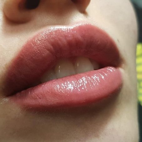 Close-up van zachte, volle lippen met een lichte glans.
